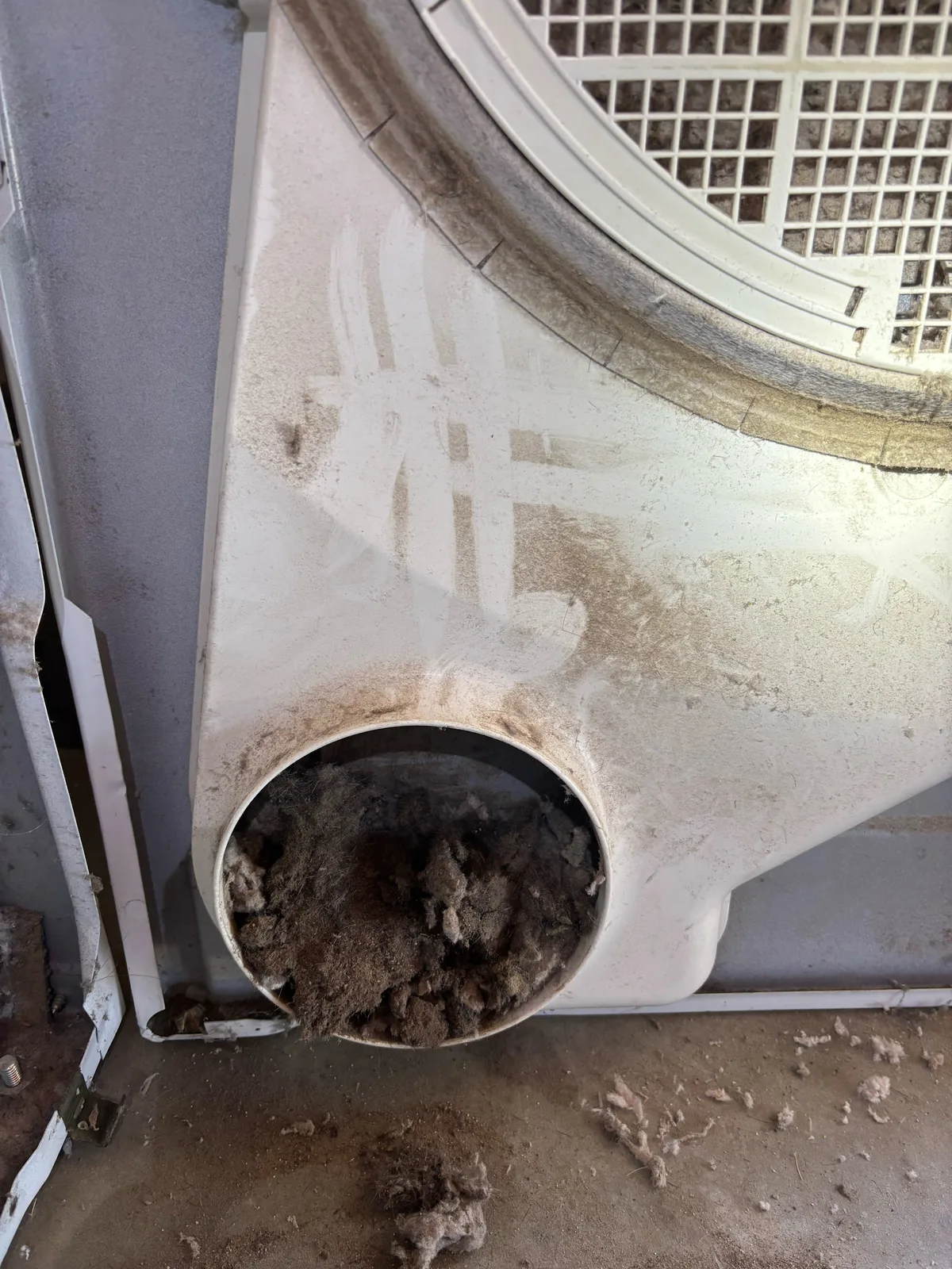 Lint packed into an internal dryer air passage, photographed during service